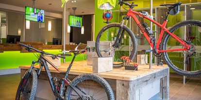 Mountainbike Urlaub - Fitnessraum - Tirol - Bike Area mit Werkbank, Sportlockern, Tourenvorschlägen an der Explorer Wall und Verleih von E-Mountainbikes. - Explorer Hotel Kitzbühel