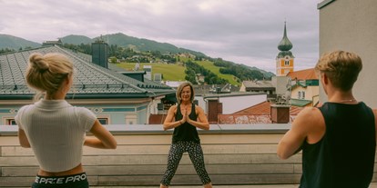 Mountainbike Urlaub - veganes Essen - Flachau - Yoga im Freien auf der Terrasse mit Blick über die Dächer von Schladming - Stadthotel Brunner