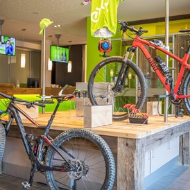 Mountainbikehotel: Bike Area mit Werkbank, Sportlockern, Tourenvorschlägen an der Explorer Wall und Verleih von E-Mountainbikes. - Explorer Hotel Kitzbühel